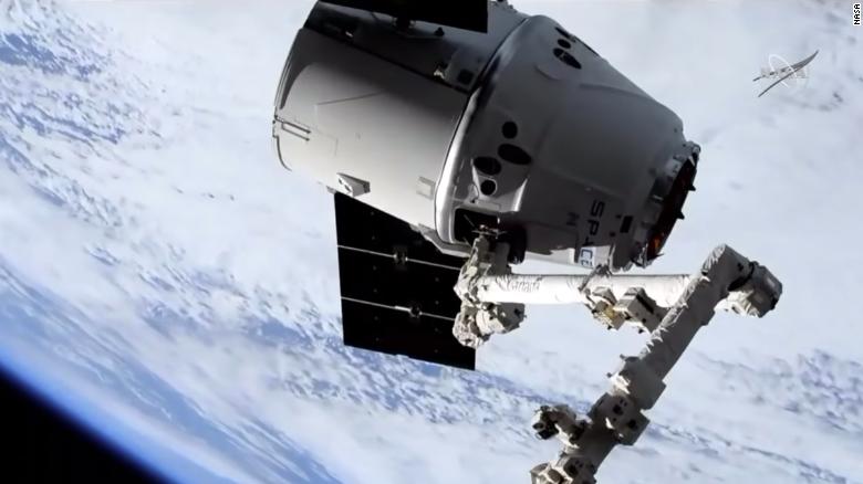 Giant robotic arm catches SpaceXs Dragon cargo spacecraft
